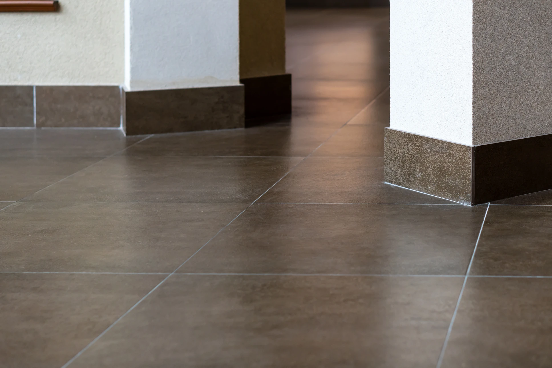 L'ouvrier du bâtiment coupe les surfaces de carrelage céramique avec des outils et de l'équipement manuels afin de poser des carreaux céramiques sur le sol